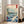 Contemplative framed poster of a Japanese seascape with rocky outcrops, soaring birds, and a boat on blue-green waters beneath distant peaks.
