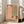 Japandi-style wall art showing an elegant contemplative room with arched window, lush florals, peacock motif, and decorative carpet in soft terracotta and cream palette.