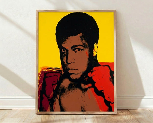 Bold pop art portrait of Muhammad Ali in vibrant colors, screen-printed poster style with high-contrast graphic treatment.