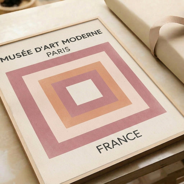 Framed poster with layered geometric squares in soft pastels and black, reflecting Bauhaus minimalist principles.