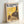 Studio Ghibli poster depicting Totoro gazing at a dandelion seed head, captured in a dreamy composition with cream and gold accents against a darkening sky, evoking quiet wonder.