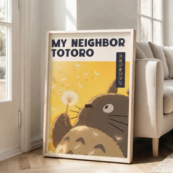 Framed Ghibli-inspired artwork of Totoro surrounded by soft dandelion imagery, painted in soothing yellows, browns, and cream with darker navy undertones, radiating gentle nostalgia.