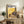 Anime wall art featuring the beloved Totoro character with a blooming dandelion, rendered in warm earthy tones and gold highlights against a peaceful sunset backdrop inspired by Studio Ghibli.