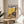 My Neighbor Totoro poster art showing the iconic forest spirit with a delicate dandelion flower, combining soft cream and yellow hues with navy blue in a tender, whimsical composition.