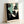 Framed minimalist poster art depicting an abstract woman's portrait in cream, black, and teal with bold graphic shapes and underground retro sensibility.