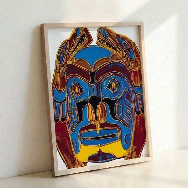 Colorful framed poster showcasing a traditional Northwest Coast mask rendered in vivid Pop art aesthetic with flat planes of saturated color and graphic line work.