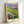 Framed art print displaying floating water lilies in an impressionist style with pale yellows, soft blues, and green foliage in a tranquil pond setting.