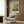 Impressionist garden scene framed as wall art with water lilies and reflective pond rendered in pale yellow, blue, and green creating contemplative atmosphere.