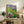 Impressionist poster art of floating Nympheas blossoms and foliage in luminous soft blues and greens evoking a quiet garden moment.