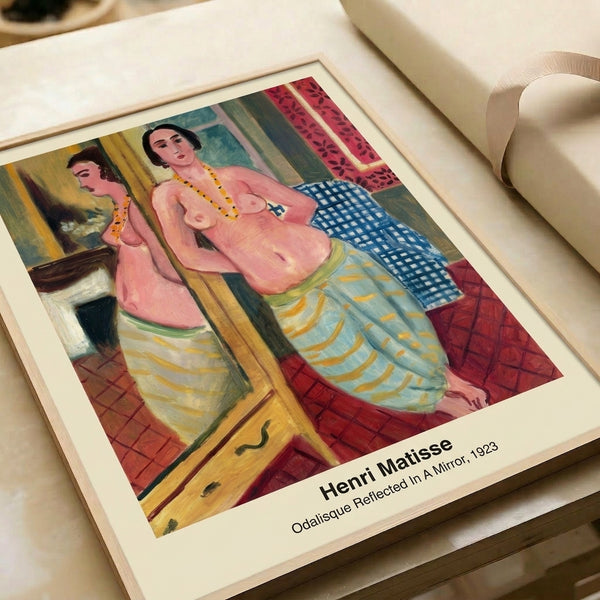 Framed modern print depicting a reclining woman observing her mirror reflection in an interior space, composed with sensual lines in coral, ochre, deep blue, and cream.