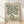 Minimalist Japandi still life poster featuring an olive branch with delicate leaves arranged in a cream vase against a warm white background, framed on a wall.