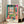 Vibrant modern poster depicting an interior room with an open window and harbor vista, using optically dynamic color blocking in warm and cool tones.