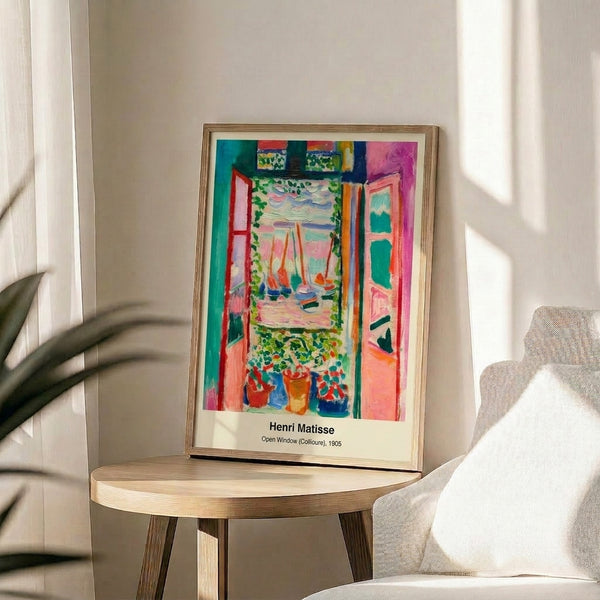 Framed contemporary art print showing a balcony view with flowerpots and sea landscape, rendered in abstract style with striking combinations of blue, fuchsia, and ochre.