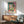 Abstract window artwork in bold modernist style featuring warm and cool color contrasts, a glimpsed harbor view, and interior elements arranged as a dynamic composition.