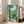 Mid-century modern art print depicting an open window view into a peaceful greenhouse filled with potted plants, featuring a calming palette of yellow-green, cream, and blue hues.