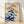 Framed Japanese woodblock print of orange and cream tiger lilies with sage green leaves and stems on navy blue background, serene botanical artwork in minimalist Japandi style.