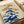 Serene botanical wall art print depicting delicate tiger lilies in warm orange and cream tones with sage and navy blue accents, inspired by traditional Japanese woodblock technique.