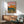 Modern nature-inspired wall art depicting serene mountain landscape with snow-capped peaks in white and warm sunset hues of pink and orange against deep teal sky.