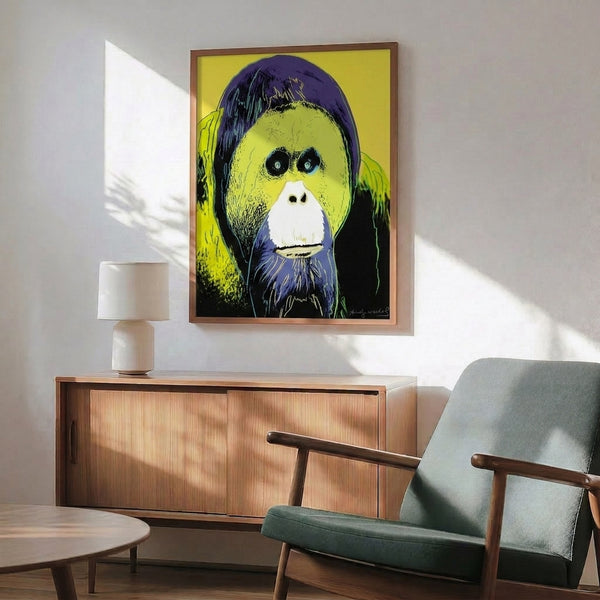Bright, energetic orangutan portrait in pop art style with layered colors of purple, orange, and cyan, framed on a wall.
