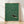 Minimalist Japanese woodblock-style framed poster of an otter swimming through forest green water with black line work and cream background, evoking serene natural contemplation.