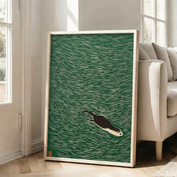 Framed art print featuring a swimming otter rendered in the Japanese woodblock tradition with earthy tones of green, rust, and cream against flowing water lines.