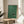 Serene wall art depicting an otter in motion through stylized water, executed in minimalist black line art with forest green and rust accents on cream paper.