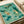 Vintage-style Japanese woodblock poster displaying three otters with seaweed and fish in a whimsical composition, showcasing calming earth tones of cream, dark green, and teal.