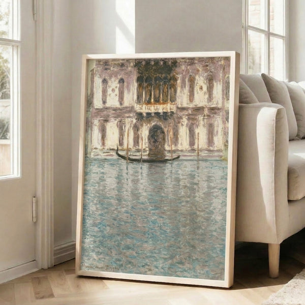 Framed wall art depicting venetian architecture and waterway in impressionist technique, with luminous pale blue and warm neutral palette.