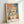 Whimsical abstract composition with two simplified human forms rendered in warm ochre and cool slate blue, characteristic of Klee's introspective modernist style, hung as a poster.