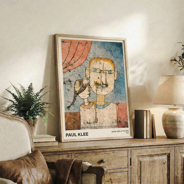 Framed modernist print with two stylized faces in burnt sienna, ochre, and slate blue creating an introspective, whimsical composition in Klee's distinctive abstract manner.