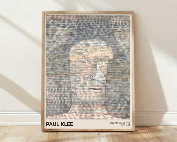 Paul Klee's Athlete's Head, a geometric abstraction featuring an angular faceless portrait in cream, grey-blue, salmon-pink, and olive tones, framed on a wall.