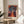 Abstract autumn flower artwork with geometric vase and contemplative mood, featuring a sophisticated palette of burgundy red, slate gray, ochre, and deep blue.