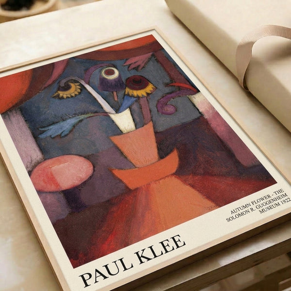 Modern Bauhaus-inspired framed print depicting an imaginative flower-and-face composition in warm rust orange and cool slate gray with hints of burgundy and ochre.
