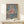 Geometric portrait in the style of Paul Klee showing a figure in formal attire with a floating halo, executed in soft grays, reds, and pastel tones.