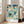 Geometric abstract poster inspired by Bauhaus principles, with interlocking shapes in yellow, gray, and green creating a serene architectural composition.