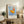 Minimalist poster art with a stylized figure holding a stick beneath a golden sun, combining Bauhaus design principles with warm and cool tones.