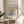 Framed modern poster displaying a whimsical Bauhaus composition of a figure and celestial forms in cream, sky blue, and golden hues with contemplative character.
