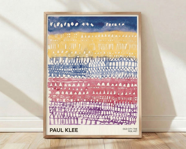 Bauhaus-style framed poster of an abstract old city with geometric buildings in navy blue, golden yellow, dusty rose, and purple tones.