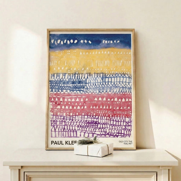 Abstract architectural wall art in modernist style showing stacked buildings rendered in navy, dusty rose, and yellow on cream background.