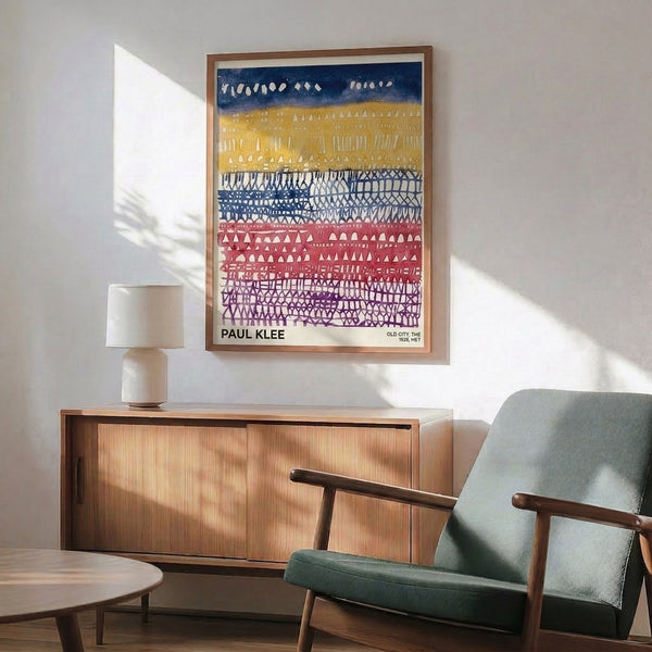 Minimalist framed print of an abstract urban landscape with interlocking geometric forms in navy blue, golden yellow, purple, and dusty rose.