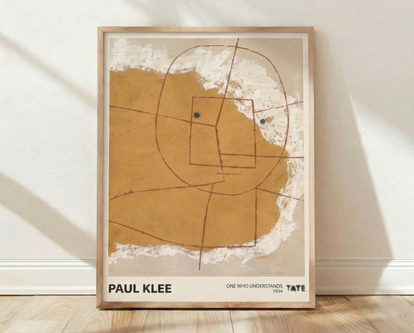 Abstract geometric portrait by Paul Klee titled One Who Understands, featuring a stylized face in ochre, tan, and burnt sienna tones on cream background, exemplifying Bauhaus minimalist design.