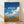 Minimalist framed poster featuring a serene VW van parked in a golden tan field beneath a soft blue sky with white clouds, evoking a peaceful, reflective mood.