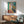 Elegant abstract wall art featuring a simplified nude figure in soft pastels and muted cream tones, positioned contemplatively by a window in minimalist modern style.