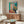Soft palette abstract wall art combining cream, beige, and warm peach, depicting a figure in a contemplative pose with simplified geometric forms.