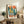 Vintage-style framed art print showing an urban piano motif blending with geometric buildings and a warm sun, evoking nostalgic midcentury design in earthy oranges and greens.