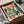 Nostalgic retro poster combining jazz-era piano imagery with a warm, geometric New York City skyline in vintage midcentury colors including charcoal, cream, and burnt orange tones.