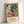 Framed exhibition poster in Art Deco and Bauhaus aesthetics, displaying geometric abstraction of human and avian figures in striking teal and rust red against cream background.