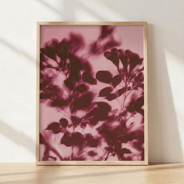 Soft watercolor botanical silhouette in rose pink and mauve tones featuring delicate flower stems and leaves on a cream background, framed as a minimalist wall art print.