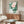 Minimalist Japanese-inspired botanical poster of a soft pink water lily with layered green foliage, creating a serene zen composition on wall.