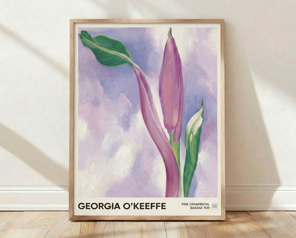 Soft watercolor painting of a pink banana flower with layered petals in rose and lavender tones, surrounded by sage green leaves in a serene botanical composition.